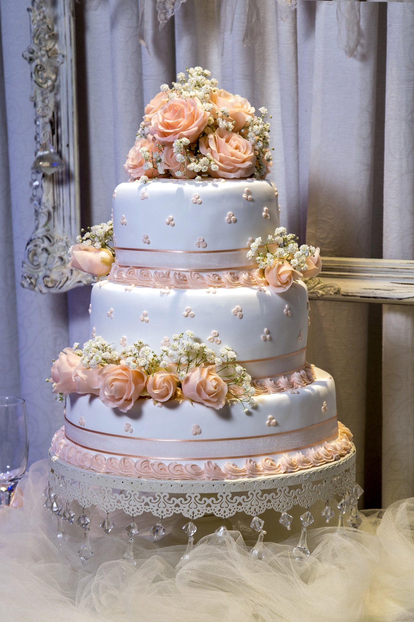 vertical-closeup-shot-beautiful-three-layered-cake-with-rose-decorations